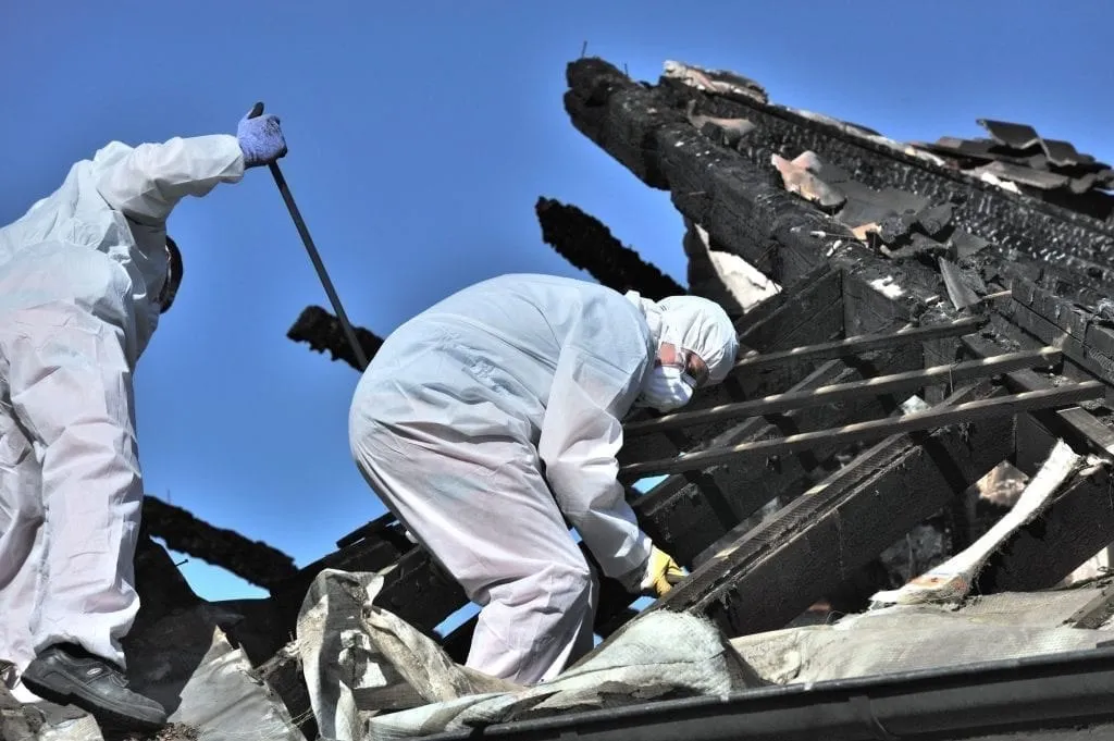 Fire restoration technicians working on a heavily damaged structure